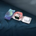 A white 3-in-1 wireless charger displaying a smartphone, smartwatch, and earbuds on a blue surface.