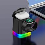 A black 4-in-1 wireless charger with a colourful base, featuring slots for AirPods and an Apple Watch, beside a laptop.