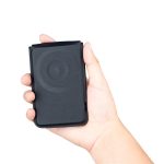 A black magnetic card wallet and wireless charging stand held in a hand. It features a logo on the surface.