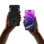 A black magnetic wireless charging station held in one hand, with a smartphone in the other hand displaying a gradient screen.