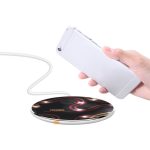 A wireless charger featuring a sleek black design with flowing red and white patterns, accompanied by a mobile phone.