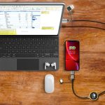 A fast charge and data sync LED cable connects a smartphone to a laptop, with earphones and a mouse nearby.