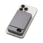 A grey Eco Magnetic Wireless Power Bank atop a smartphone, featuring a sleek, compact design and a logo.