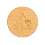 A round bamboo coaster with a engraved design of a mountain and palm tree, featuring a logo.