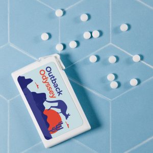 A rectangular container of sugar-free breath mints with a colorful design, accompanied by white mints scattered around it.