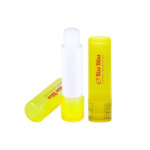 A yellow lip balm stick with a white cap, featuring a logo and standing upright alongside its container.