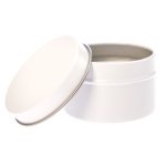 A petite candle in a white tin container with a removable lid.