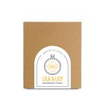 A large brown box with a circular label featuring a floral design and branding for "Lila & Lily Fragrance Studio."