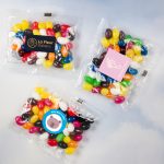 Assorted mini jelly beans in various colors, packaged in 50-gram cello bags with branding.