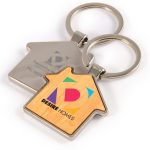 A house-shaped keytag with a bamboo and zinc design featuring a colorful logo and contact information.
