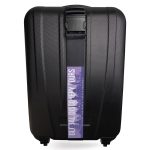 A black hard-shell suitcase with a luggage strap featuring a logo across the front.