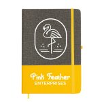 A grey and yellow A5 notebook with an illustration of a flamingo and a logo on the cover.