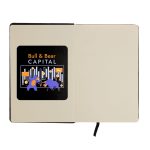 An A5 notebook with a black cover and an illustration featuring a bull and bear on the inner page, includes a logo.