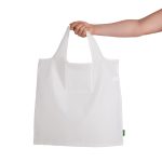A white reusable grocery bag is held by a hand, featuring a logo on the side.