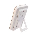 A weather station device with a sleek white design and a foldable stand for easy placement.