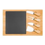 A bamboo cheese board with a slate section and four stainless steel knives with wooden handles.