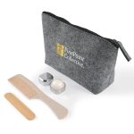 A grey toiletry bag with a zip, containing a comb, wooden stick, and two containers. The bag features a logo.