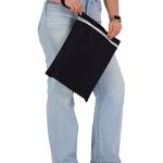 A black wet bag being held by a person, featuring a white zip and a sleek design.