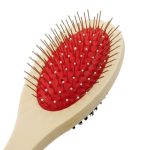 A pet grooming brush with a red bristle pad and white plastic handle, featuring a logo on the side.