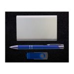 A silver card holder, a blue pen, and a blue USB flash drive arranged against a dark background.