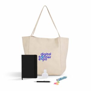 A beige tote bag contains a black notebook, a drink bottle, a pen, and colourful candies. It features a logo.