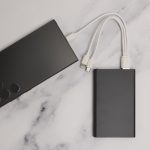A sleek, black Octavius 4,000mAh Power Bank with multiple charging cables attached is displayed on a marble surface.