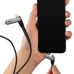 A hand holds a Volt Combo Cable with multiple connectors, plugging into a smartphone. The cable features a sleek design and a logo.