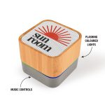A bamboo Bluetooth speaker with flashing coloured lights and music control buttons, featuring a logo on the top.