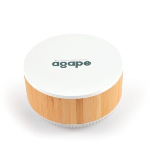 A round speaker and wireless charger in white and bamboo, featuring a logo on the top.