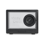 A black speaker with a prominent circular speaker and a transparent front, featuring branding and control buttons at the bottom.