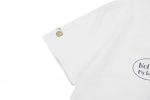 A white cotton t-shirt featuring a logo and printed designs on the front and sleeve.