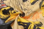 A fabric featuring a vibrant design with black and yellow illustrations on a tan background, including whimsical characters.