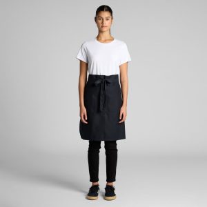 A half apron in black, featuring a front pocket and a tied waistband, displayed on a model wearing casual attire.