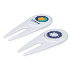 A white golf divot repairer with a marker, featuring circular designs and a logo on each side.