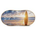 A surfboard against a beach scene with a sunset, featuring vibrant colours and a logo.