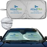 A silver car sunshade with a logo, designed to fit over a vehicle's windscreen. It folds into a compact round shape.