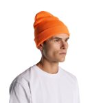 An orange beanie is worn by a model with a neutral expression, paired with a plain white T-shirt.