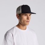 A black and beige trucker cap with a mesh back, displayed on a model wearing a white T-shirt.