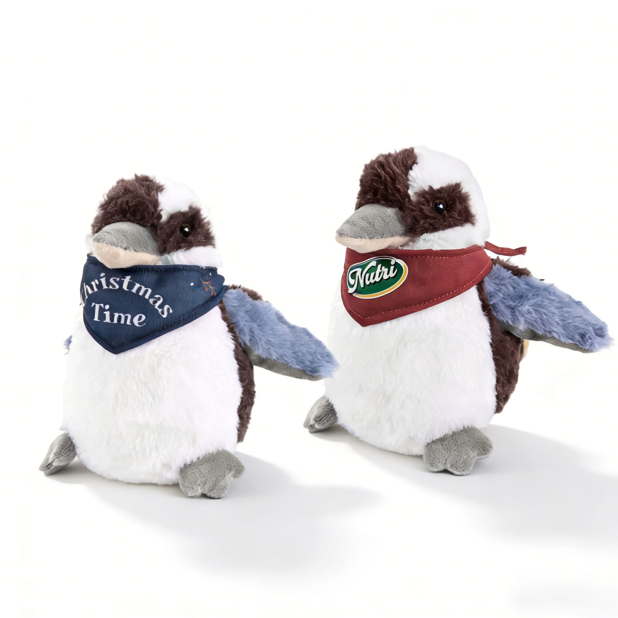 Two plush Kookaburra toys with brown and white fur, one wearing a blue bandana and the other with a red bandana, each having a logo. Kookaburra Plush Toy - Image 1