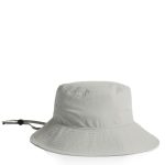 A light grey nylon wide brim bucket hat with a drawstring and a logo on the side.