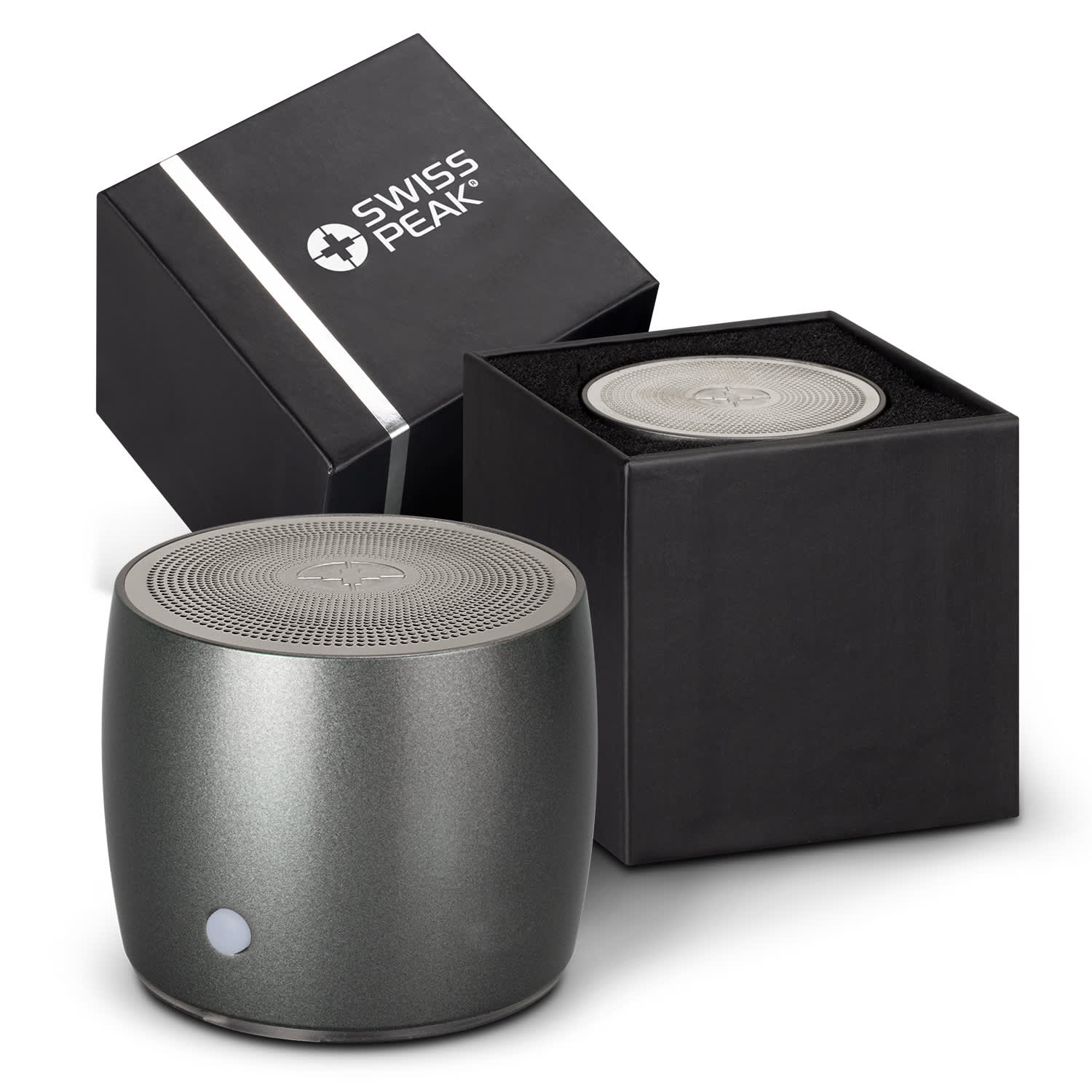 A round grey speaker with a textured top next to its black packaging, featuring a logo on the box. Swiss Peak Bass Speaker - Image 1