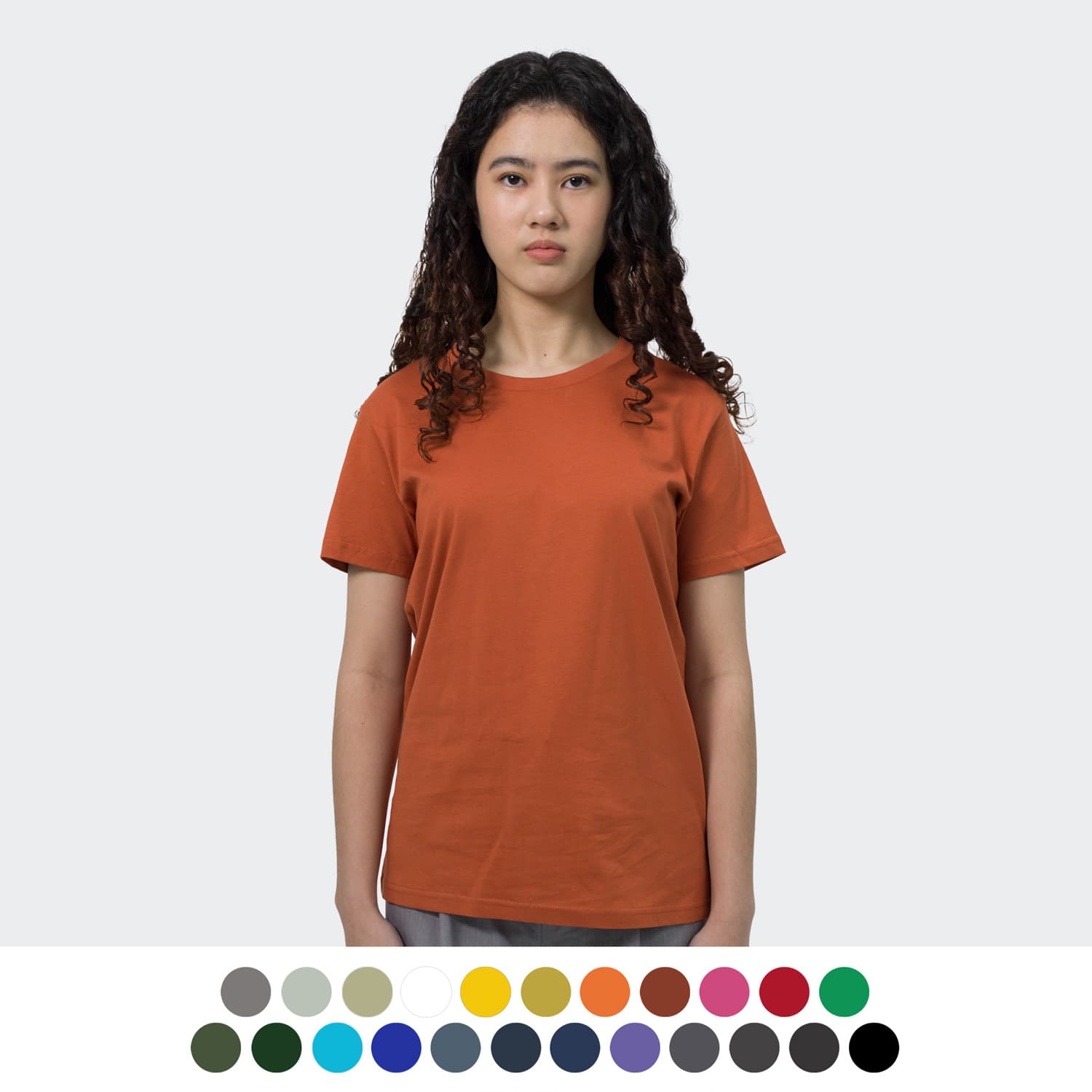 A woman wearing an orange TRENDSWEAR Original Women's T-Shirt. Various colour options displayed below. TRENDSWEAR Original Womens T-Shirt - Image 1