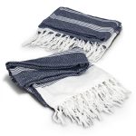 A navy and white throw blanket with a herringbone pattern and fringed edges. It is neatly folded.