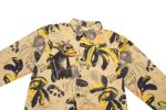 A long-sleeve shirt with a yellow banana and monkey pattern on a beige background, featuring various artistic designs.