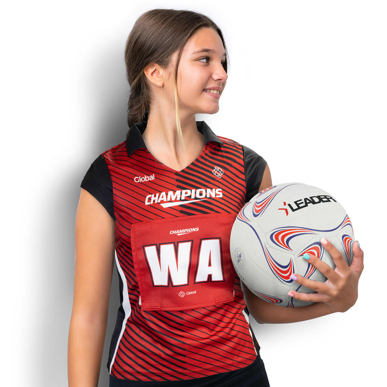 A custom women's netball bib in red and black, featuring a logo, held by a model alongside a netball. Custom Womens Netball Bib - Image 1