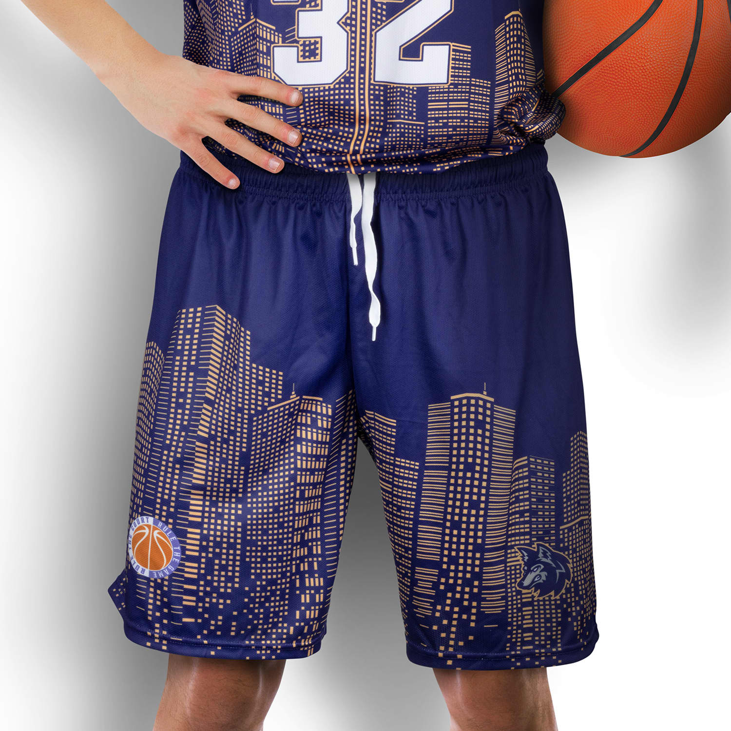 Custom men's basketball shorts featuring a navy design with a city skyline pattern and a logo. Custom Mens Basketball Shorts - Image 1