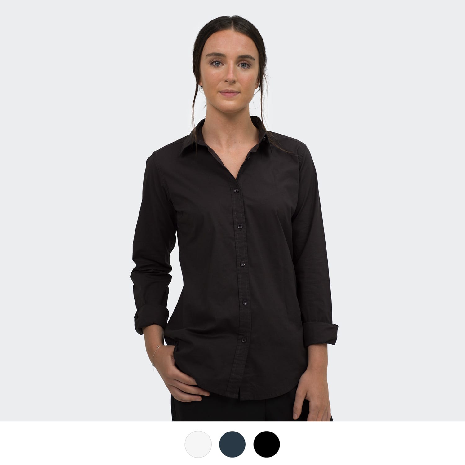 A black button-up shirt with long sleeves, featuring a collar and a logo. Model poses with one hand on her hip. TRENDSWEAR Parker Women's Poplin Shirt - Image 1