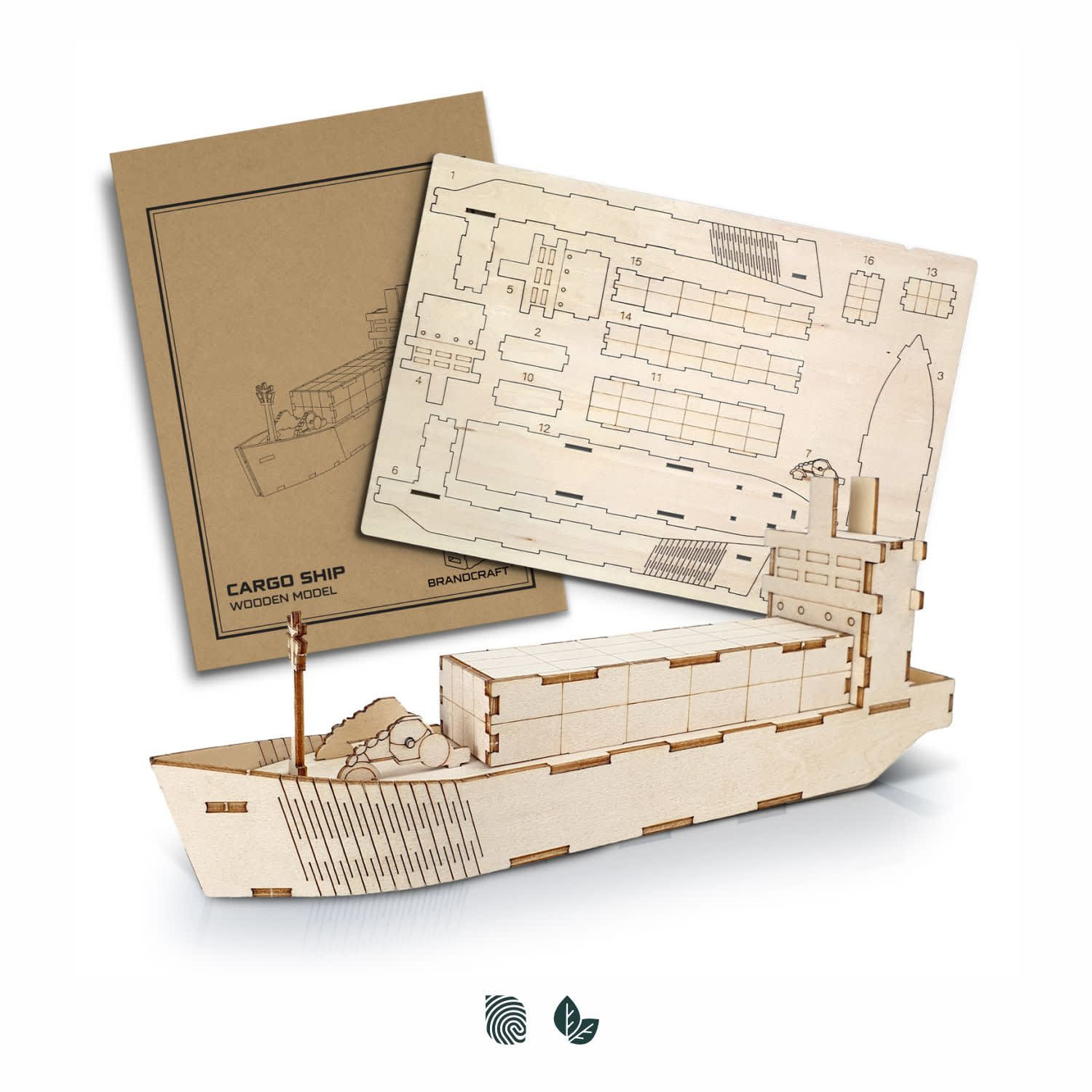 A wooden model of a cargo ship in a natural finish, alongside its assembly instructions, featuring a branding logo. BRANDCRAFT Cargo Ship Wooden Model - Image 1