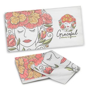 A full-colour beach towel featuring a floral design with red, orange, and green elements. It has a logo present.