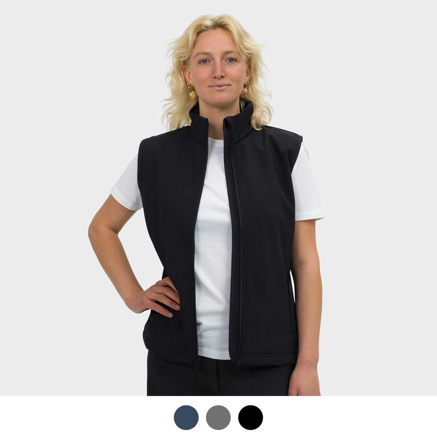 A woman models a black vest with a high collar, featuring a logo, paired with a white t-shirt. TRENDSWEAR Hudson Womens Vest - Image 1